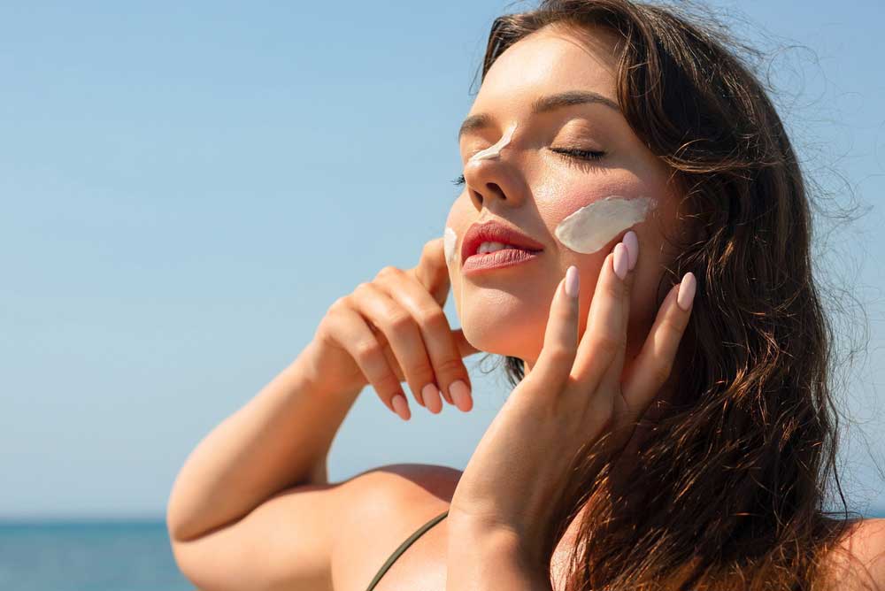 patient using sunscreen to protect skin from sun damage